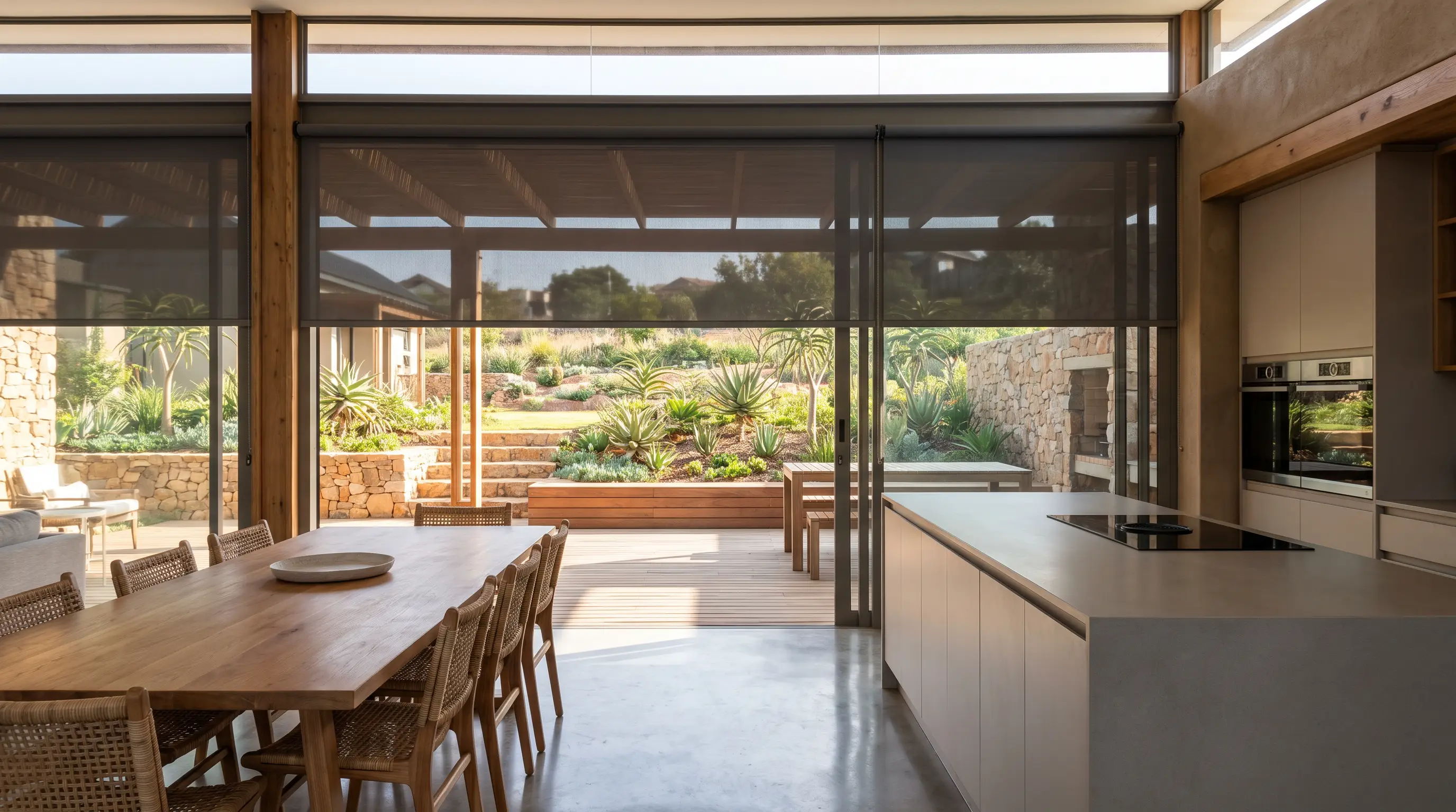 Motorised roller blinds in an open-plan kitchen and dining area of a new-build Raslouw home