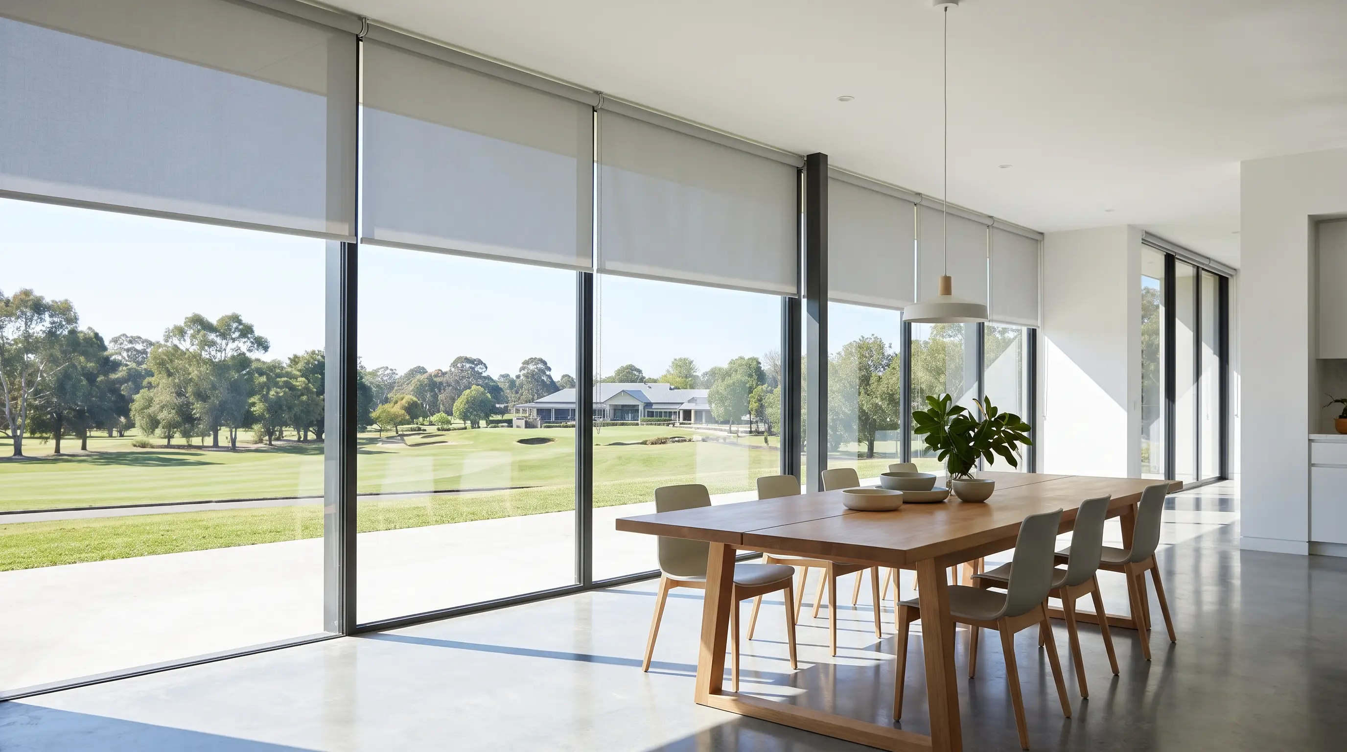 Flat sunscreen roller blinds across a wide glass wall in an open-plan dining room, Centurion Golf Estate
